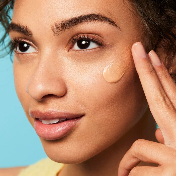 Model Applying Broad Spectrum SPF 30 Prior to Makeup