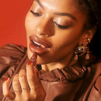 Model applying creamy lipstick