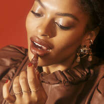 Model applying creamy lipstick